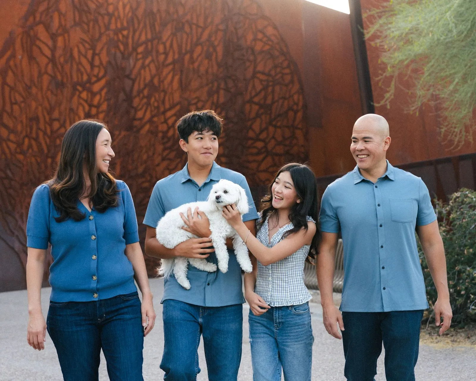 Family laughing in front of a rusted steel wall