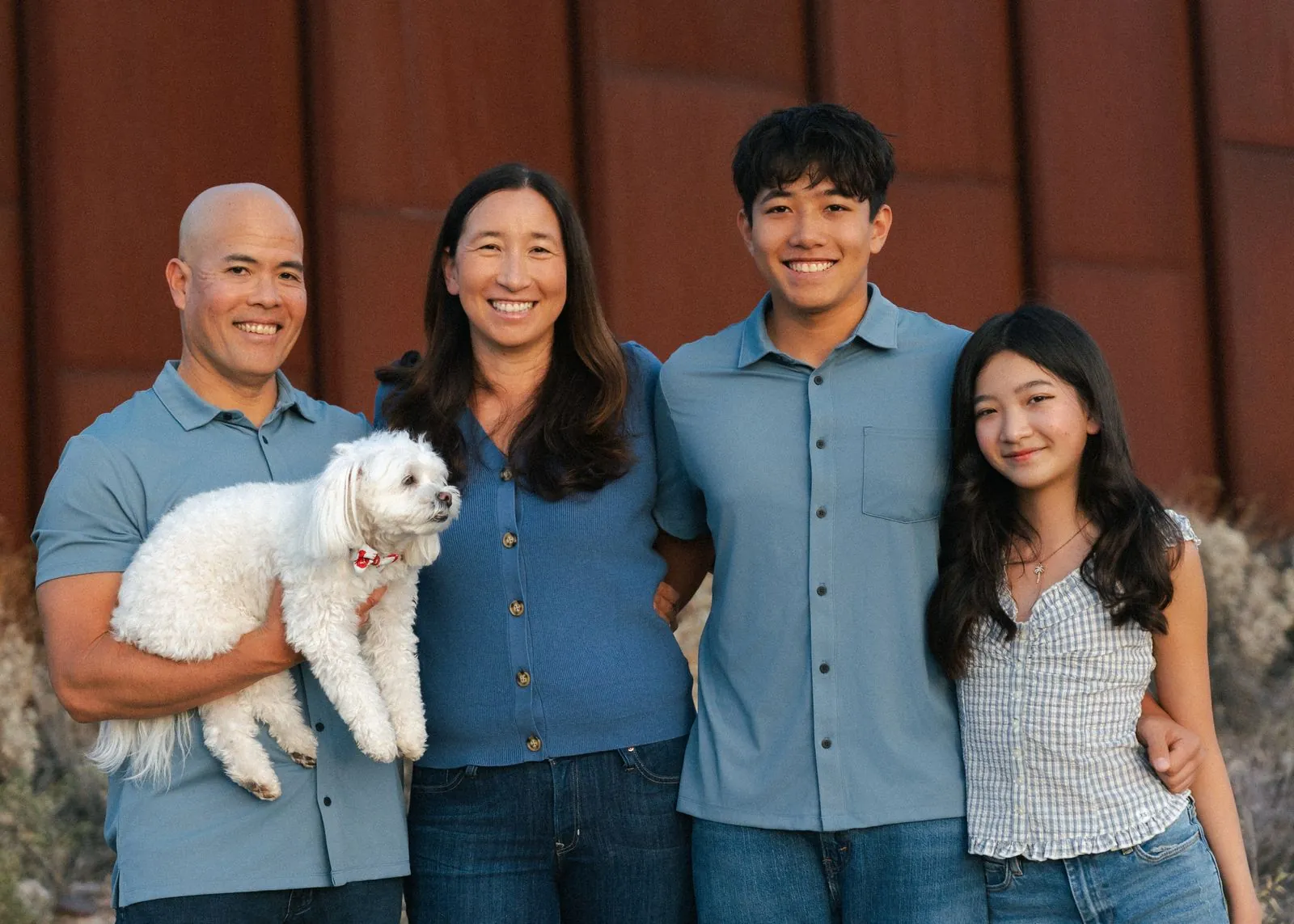 Family close-up with their fluffy white dog