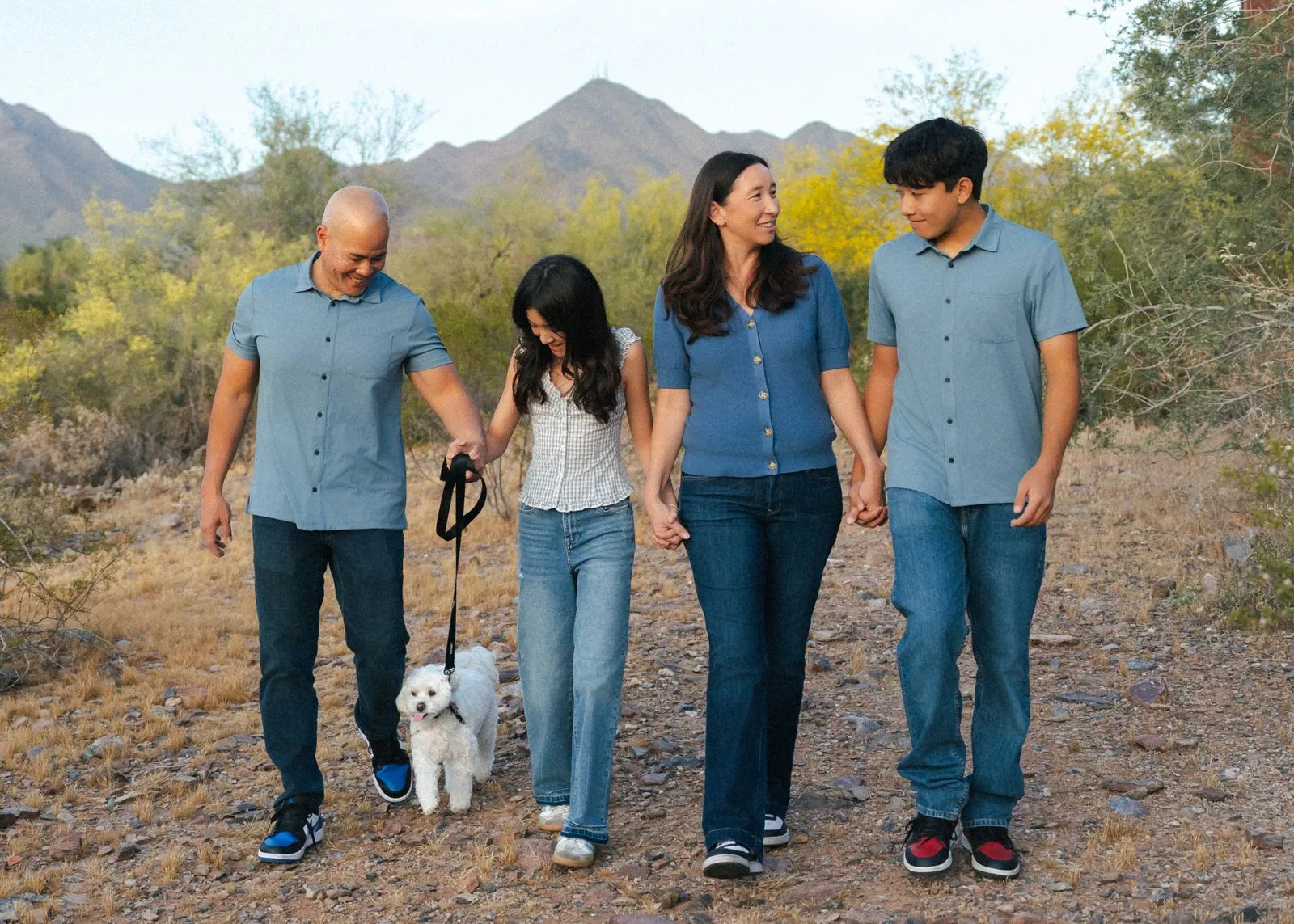 Family walking with their dog in the Scottsdale desert at golden hour