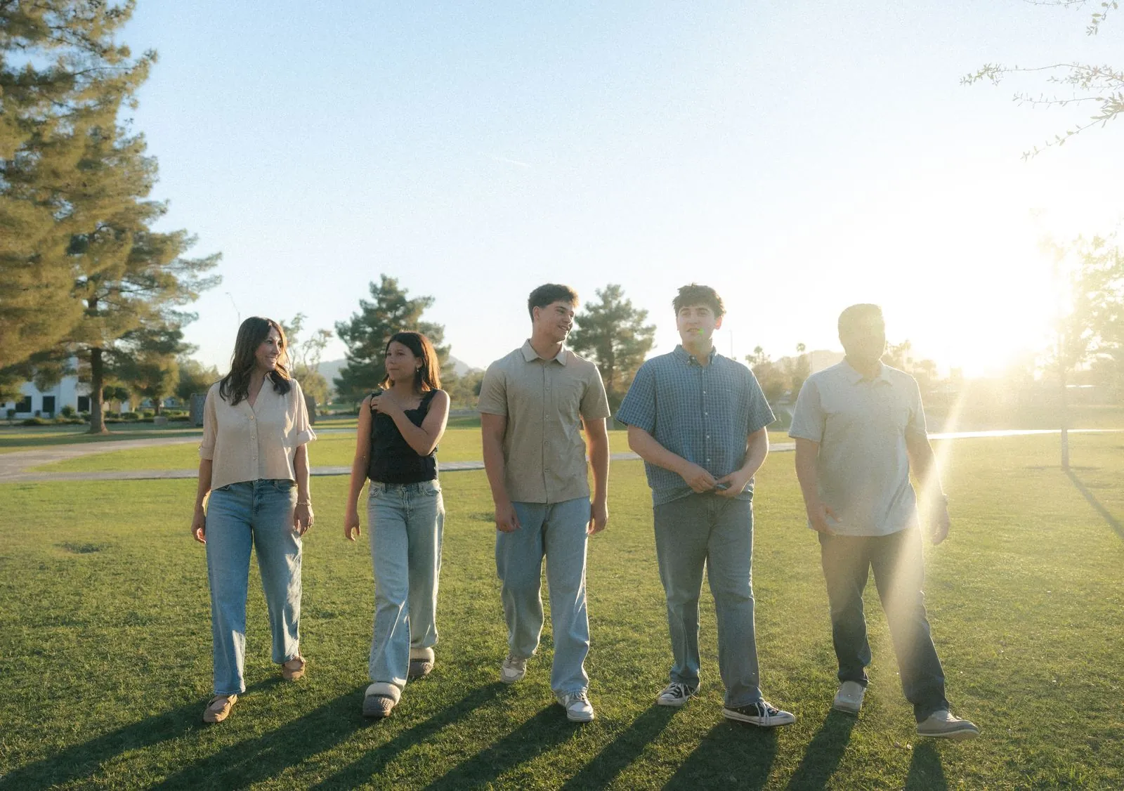 Family walking across a park at sunset