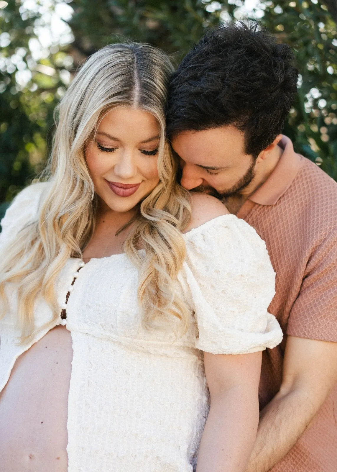 Maternity portrait of a couple cuddled up and smiling