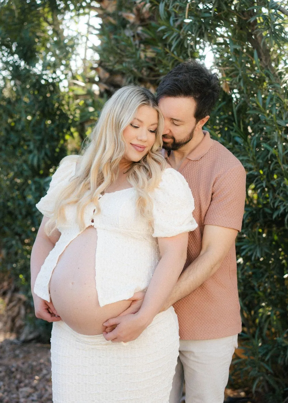 Expecting couple cuddled up and smiling