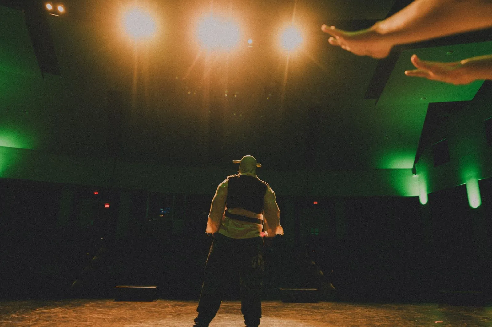 Lead actor on stage looking up into the lights